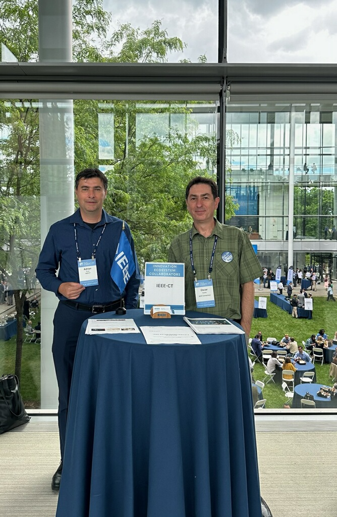 Adrian Rusu and Oscar Tonello at the Yale Innovation Summit in 2024. Adrian and Oscar are standing at the IEEE table kindly provided by the summit organizers.